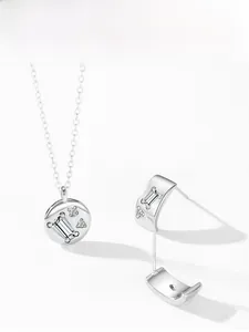 Macro view of 925 silver pendant necklace and matching hoop earrings with set crystals