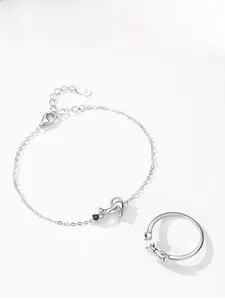 Macro detail of S925 sterling silver kitten jewelry set with blue round gemstone accents