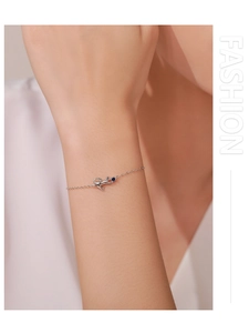 Detail of S925 silver cat bracelet featuring a blue gemstone pendant on a female wrist