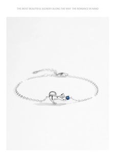 Close-up of S925 sterling silver kitten bracelet with a deep blue gemstone pendant