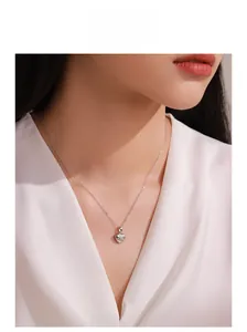 Close-up of S925 sterling silver heart pendant necklace worn by a model on white satin