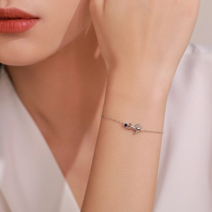 Minimalist S925 sterling silver cat bracelet with a blue gemstone on woman's wrist