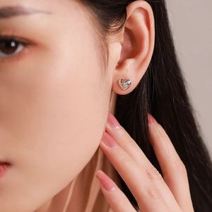 Elegant 925 sterling silver heart stud earrings with starburst zircon on model