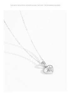 Macro shot of S925 sterling silver heart pendant with starburst engraving and zircon