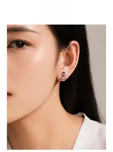Gros plan d'une boucle d'oreille chat en argent 925 avec saphir bleu sur un mannequin femme