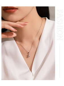 Gros plan du pendentif chat en argent avec gemme bleue sur une chemise en satin
