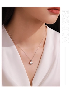 Close-up of a 925 sterling silver heart necklace with starburst detail on a model