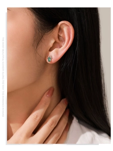 Gros plan de boucles d'oreilles renne en argent 925 avec pierre verte sur le mannequin