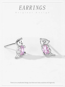 Macro detail of 925 silver koala earrings with pink oval gemstone in a claw setting