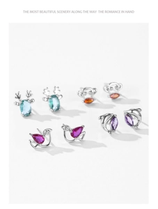 Detailed view of silver animal stud earrings set with colorful pear-shaped gemstones