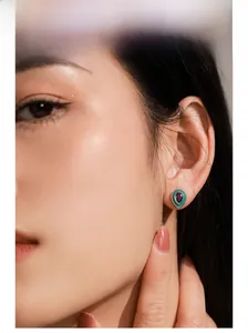 Gros plan détaillé de boucles d'oreilles améthyste avec émail vert sur l'oreille