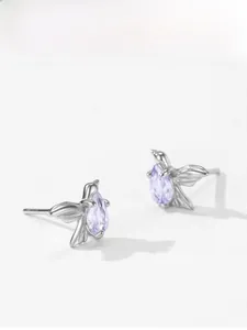 Detail view of 925 sterling silver swallow earrings with pear-cut purple gemstones