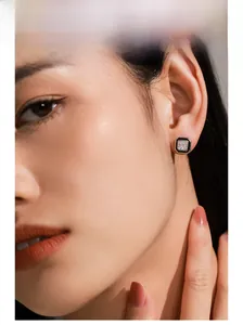 Model wearing square S925 silver stud earrings with step-cut zircon and enamel detail