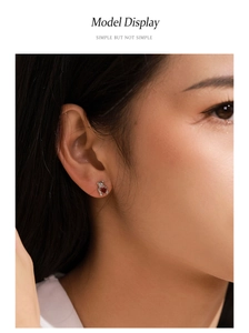 Gros plan de boucles d'oreilles ours en argent 925 avec zircon cœur rouge sur modèle