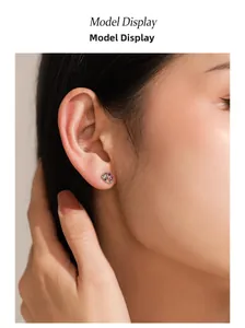 Détail de boucles d'oreilles dauphin en argent 925 avec pierre violette sur le mannequin