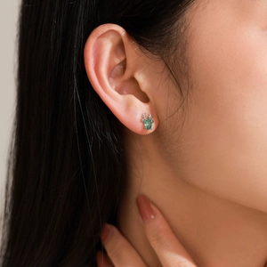 Boucles d'oreilles renne en argent 925 avec gemme verte portée par un mannequin