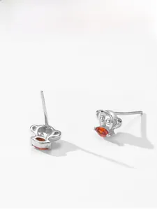 Detail of silver monkey stud earrings with orange marquise-cut zircon insets