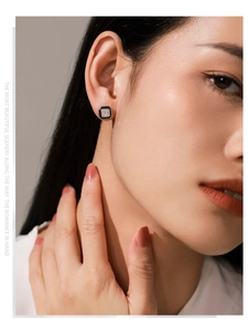 Close-up of S925 silver square zircon stud earrings with black enamel on model ear