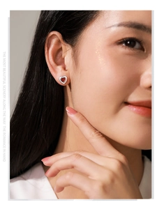 Gros plan de boucles d'oreilles cœur en argent 925 et corindon rouge sur mannequin