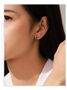 Gros plan de boucles d'oreilles ours en argent 925 avec pierre de cœur rouge sur un modèle