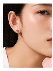 Close-up of S925 sterling silver monkey stud earrings with red accents on model