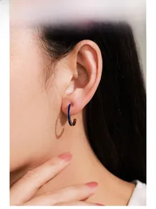 Model wearing 925 silver C-shape earrings with deep blue enamel in a minimalist style