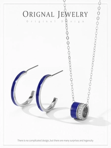 Vue détaillée du collier cylindre en argent 925 et des boucles d'oreilles émail bleu
