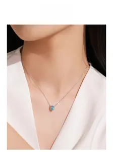Detail view of model wearing a 925 silver necklace with heart-shaped aquamarine pendant