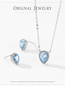 Close-up of 925 sterling silver necklace and earrings set with blue teardrop gems