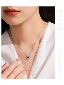Close-up of 925 sterling silver necklace featuring a deep blue stone and zircon pendant