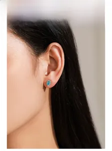 Close-up of elegant 925 silver teardrop earrings with blue gemstone on model ear