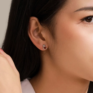Boucles d'oreilles ours en argent 925 avec gemme cœur rouge portées par un modèle