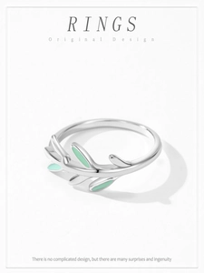 Close-up of 925 sterling silver ring with mint green enamel leaves on a white background