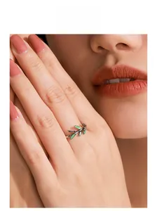Close-up of 925 sterling silver branch ring with green enamel leaves on model's finger
