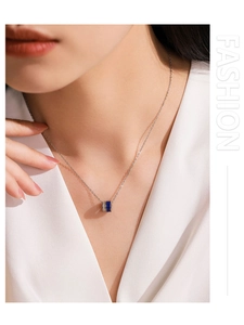 Gros plan du collier élégant avec pendentif cylindrique en émail bleu et oxydes de zirconium
