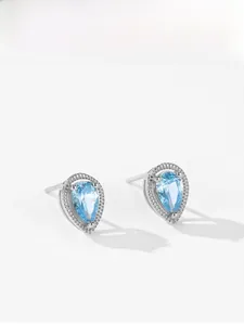 Detailed macro view of 925 silver pear cut light blue gemstone stud earrings