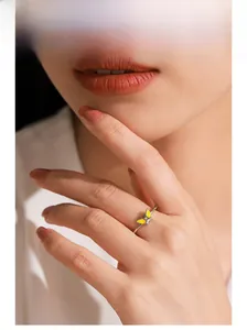 Gros plan d'une bague papillon en argent 925 avec émail jaune portée par une femme