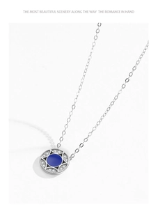 Macro shot of silver circular pendant with deep blue enamel and sparkling white zircon pavé