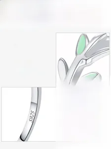Macro view of S925 sterling silver ring with green and white enamel leaf patterns