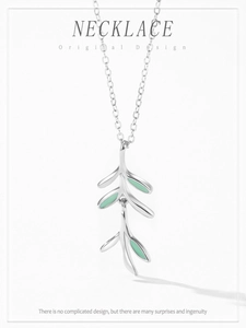 Detail of 925 sterling silver necklace featuring green enamel leaf branch pendant