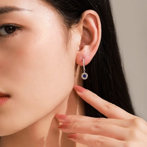 925 silver star pendant earrings featuring deep blue center stone on female model