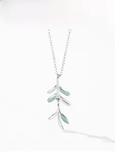 Macro detail of 925 silver branch necklace with green enamel leaves on a white background