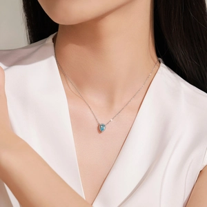 Elegant 925 sterling silver necklace with teardrop blue gemstone on female model