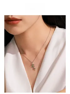 Close-up of model wearing a 925 silver necklace with green enamel leaf pendant