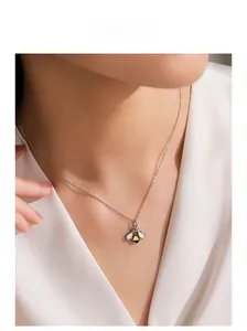 Gros plan d'un collier abeille en argent S925 avec émail jaune sur un mannequin