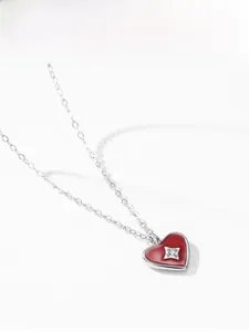 Dettaglio della collana con ciondolo a cuore in smalto rosso e zircone a stella centrale