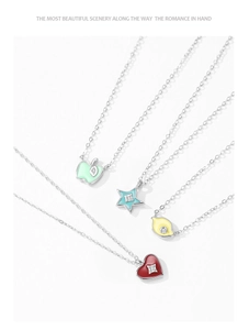 Detail view of colorful enamel charms in heart, star, apple and lemon shapes on silver chain