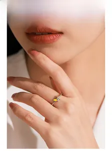 Détail de la bague papillon en argent 925 avec émail jaune sur le doigt d'un modèle