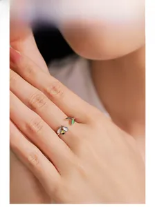 Close-up of a 925 sterling silver bee and leaf open ring worn on a finger