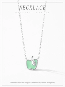 Detailed view of silver apple pendant with green enamel and sparkling zircon stone